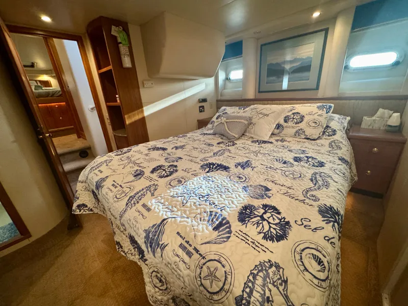 Slide: The Image of Cozy bedroom in 1999 Bayliner 5288 Pilot House Motoryacht with nautical-themed bedding. - 29
