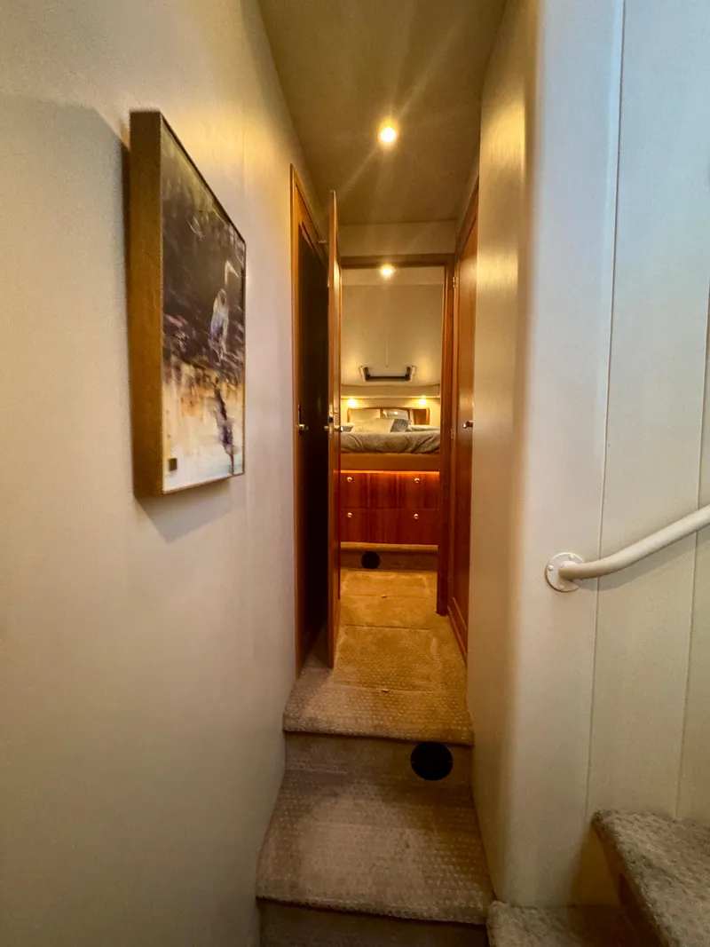 Slide: The Image of Interior hallway of 1999 Bayliner 5288 Pilot House Motoryacht, featuring warm lighting and wood accents. - 35