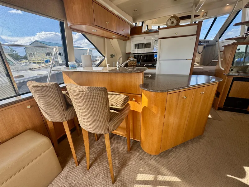 Slide: The Image of 1999 Bayliner 5288 Pilot House Motoryacht interior with kitchen and seating area. - 6