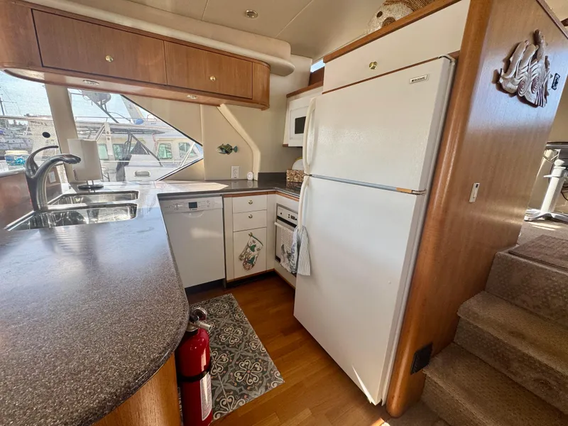 Slide: The Image of 1999 Bayliner 5288 Pilot House Motoryacht kitchen with modern appliances and wood cabinetry. - 7