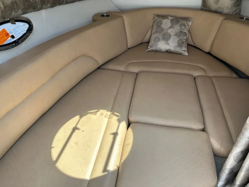 Slide: The Image of 2019 Crownline 236 SC cabin interior with beige seating and decorative pillow. - 12