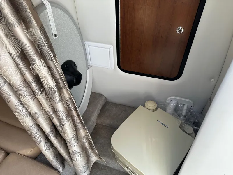 Slide: The Image of 2019 Crownline 236 SC cabin interior with compact bathroom amenities. - 7