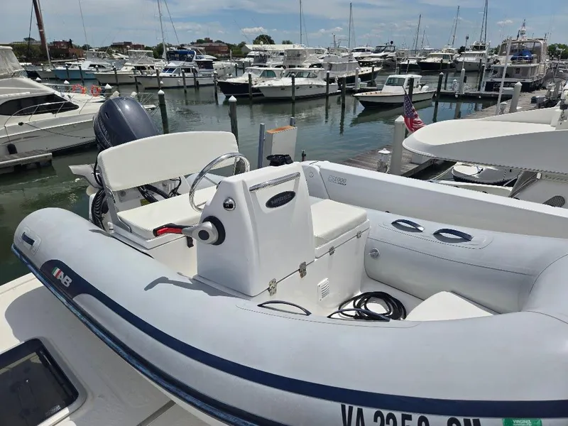 Slide: The Image of Inflatable boat docked at marina, surrounded by yachts; American Tug 49 Limited, 2010 model. - 11