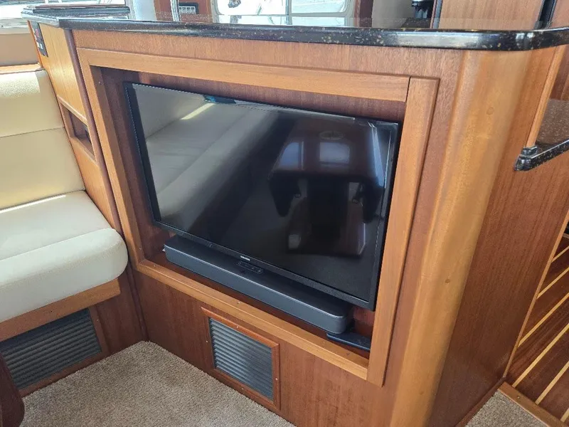 Slide: The Image of Flat-screen TV in 2010 American Tug 49 Limited yacht interior with wood paneling. - 18