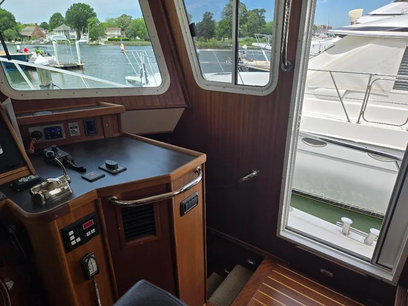 Slide: The Image of Interior view of 2010 American Tug 49 Limited, showcasing helm and marina through windows. - 28