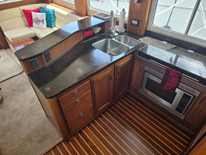 Slide: The Image of Luxurious kitchen in 2010 American Tug 49 Limited yacht with modern appliances and wood flooring. - 4