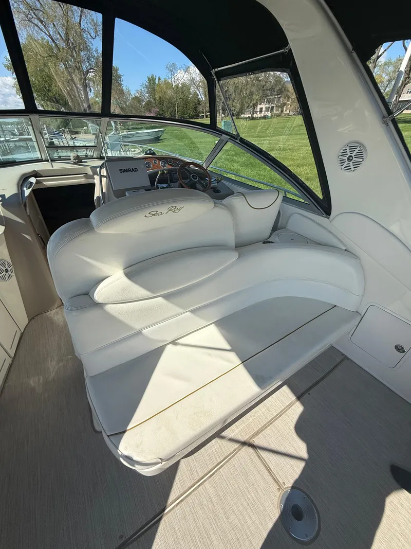 Slide: The Image of 1999 Sea Ray 340 Sundancer interior with white seating and dashboard view. - 12