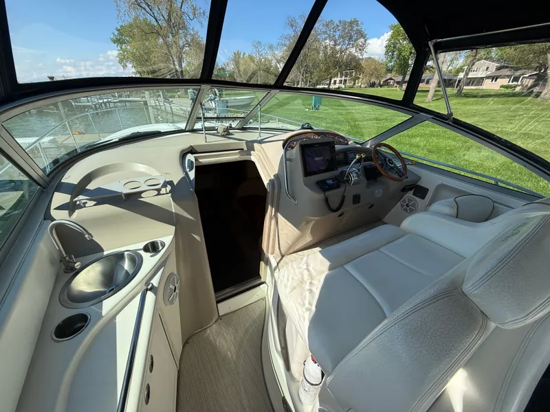 Slide: The Image of 1999 Sea Ray 340 Sundancer cockpit with steering wheel, seating, and control panel. - 16