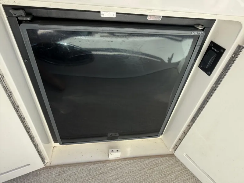 Slide: The Image of 1999 Sea Ray 340 Sundancer refrigerator compartment with closed door, showcasing sleek design. - 17