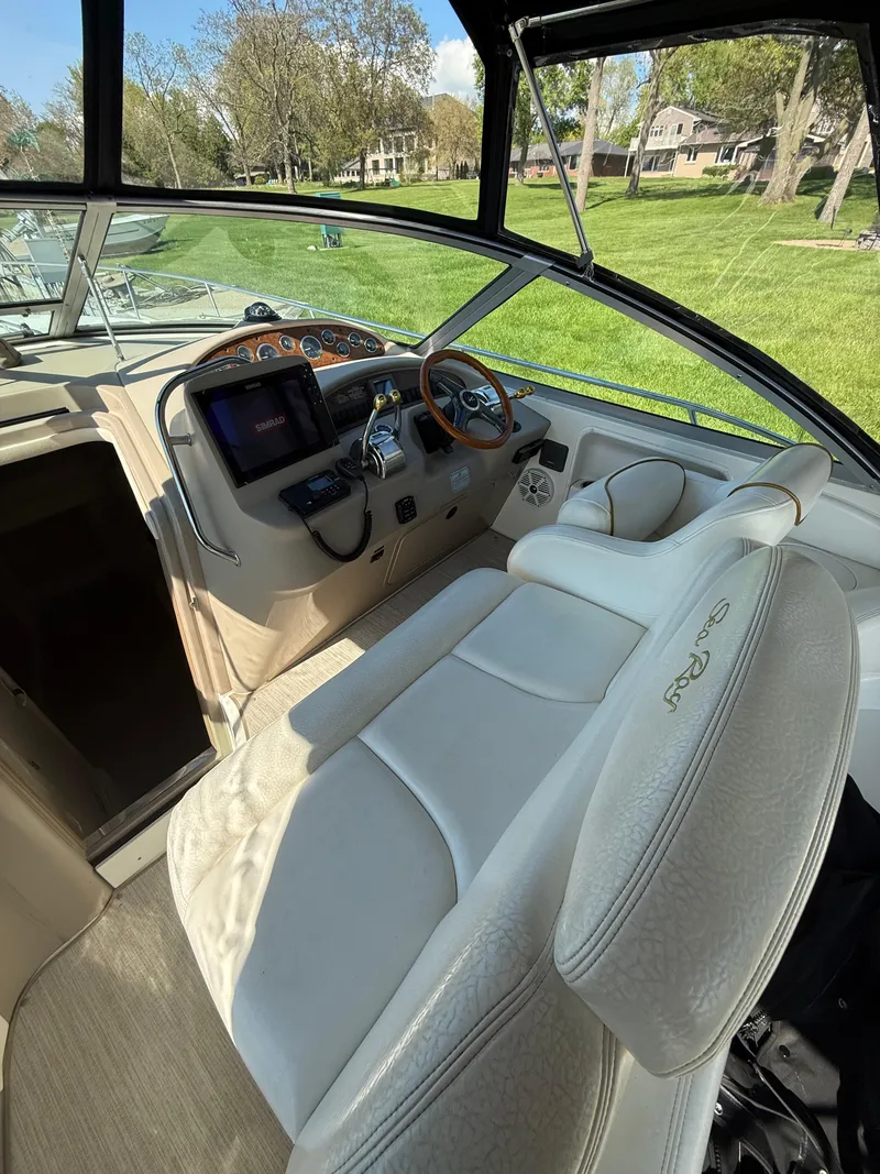 Slide: The Image of 1999 Sea Ray 340 Sundancer cockpit with steering wheel, dashboard, and white seating. - 18