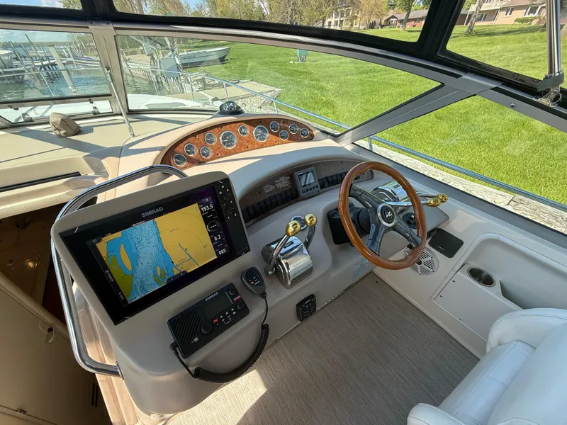 Slide: The Image of 1999 Sea Ray 340 Sundancer helm with navigation display and steering wheel. - 19