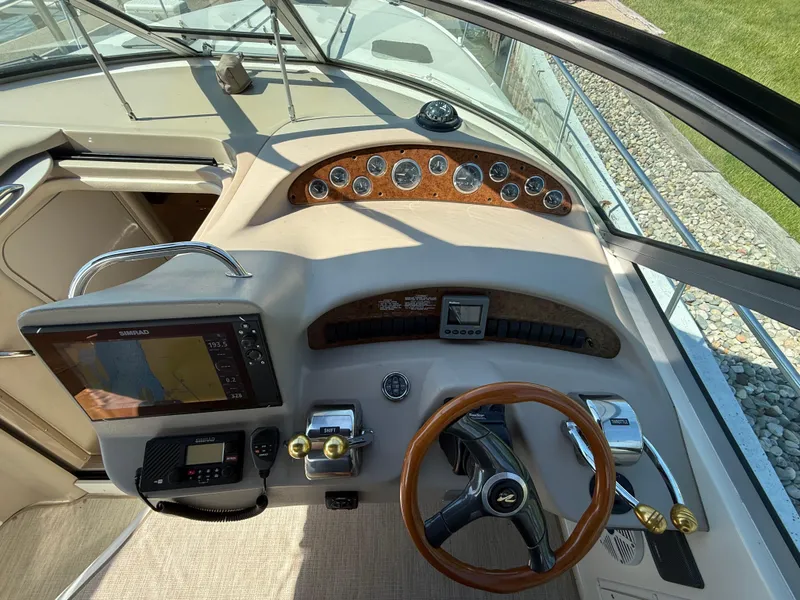 Slide: The Image of 1999 Sea Ray 340 Sundancer helm with wood accents and modern navigation equipment. - 20