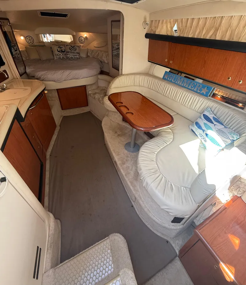 Slide: The Image of 1999 Sea Ray 340 Sundancer cabin interior with seating, table, and bed. - 21
