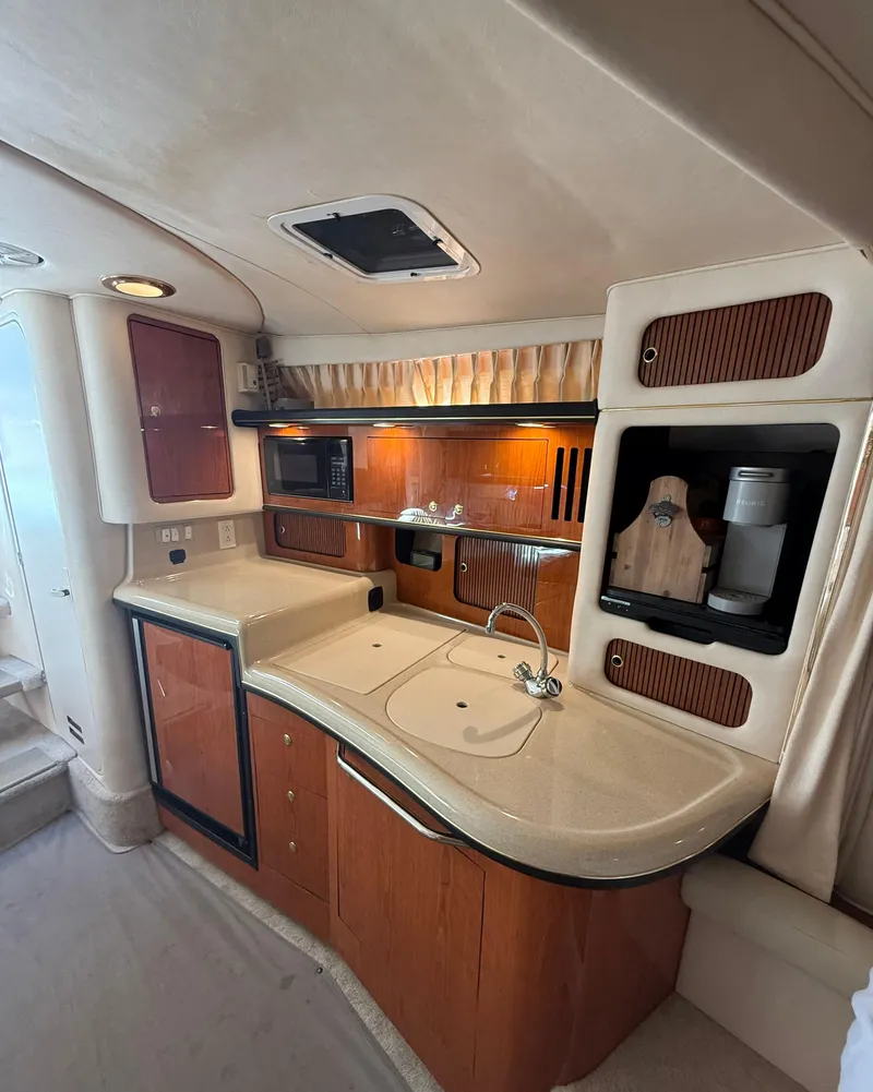 Slide: The Image of 1999 Sea Ray 340 Sundancer interior kitchen with wood cabinetry and modern appliances. - 22