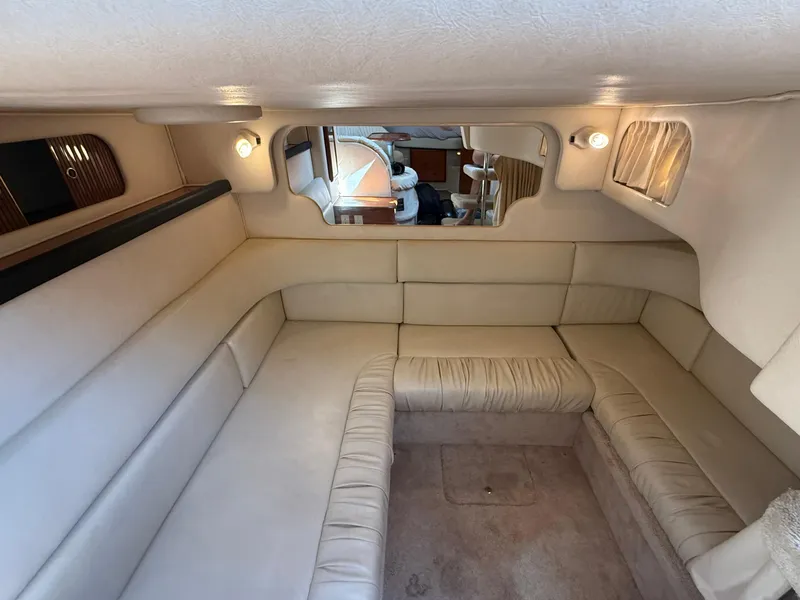Slide: The Image of 1999 Sea Ray 340 Sundancer cabin interior with beige seating and ambient lighting. - 23