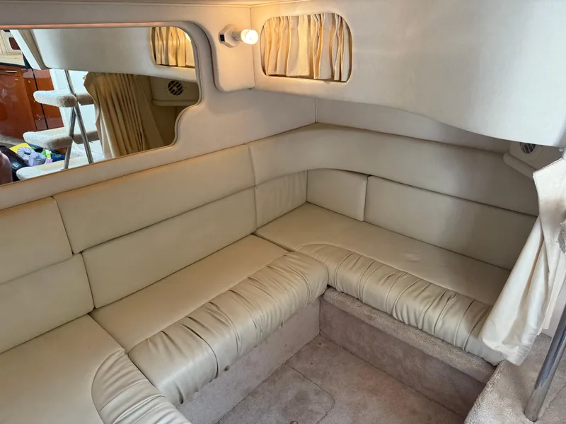 Slide: The Image of 1999 Sea Ray 340 Sundancer interior with beige leather seating and curtains. - 24