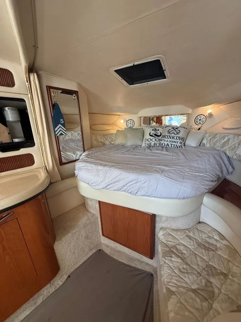 Slide: The Image of 1999 Sea Ray 340 Sundancer cabin with cozy bed and wooden cabinetry. - 28
