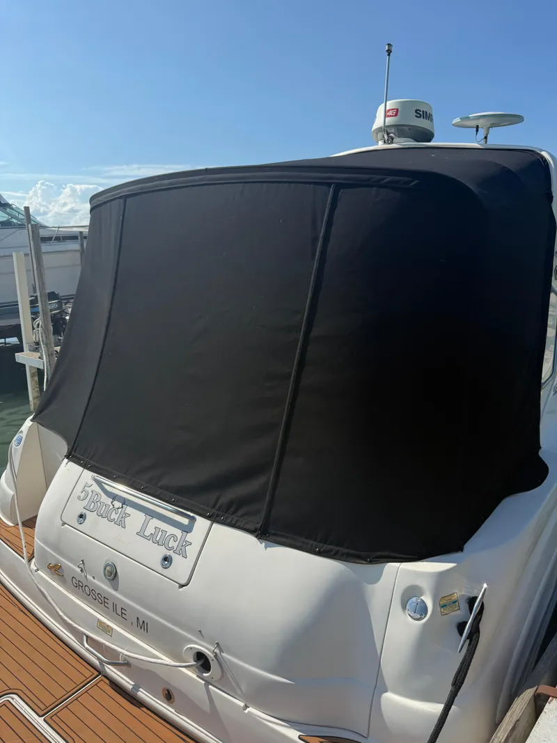 Slide: The Image of 1999 Sea Ray 340 Sundancer with black canvas cover, docked at marina. - 36