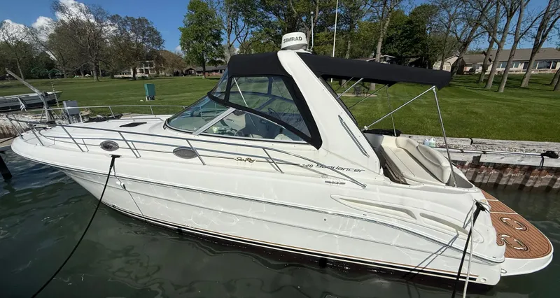 Slide: The Image of 1999 Sea Ray 340 Sundancer boat docked in a serene marina setting. - 6