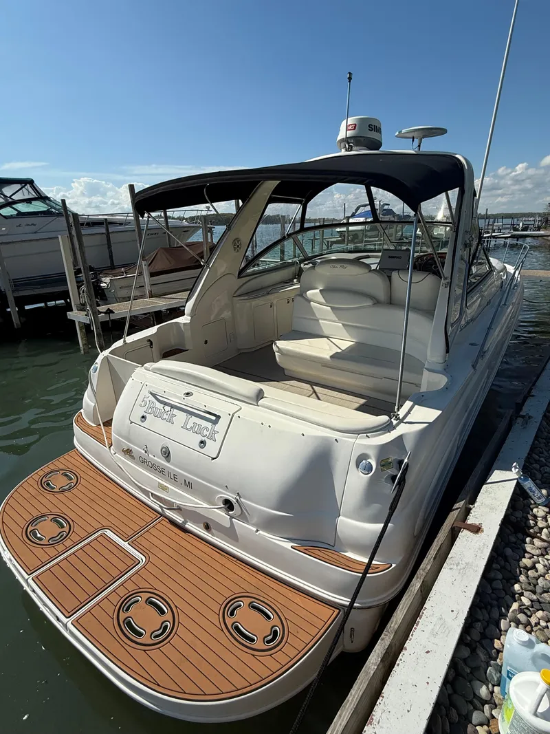 Slide: The Image of 1999 Sea Ray 340 Sundancer boat docked, featuring spacious seating and teak swim platform. - 7