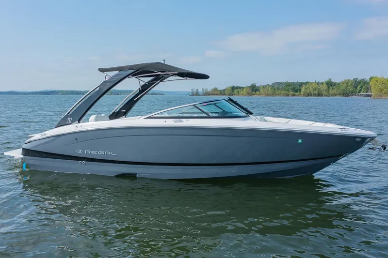 Slide: The Image of 2021 Regal LS6 boat on a calm lake under a clear sky. - 0
