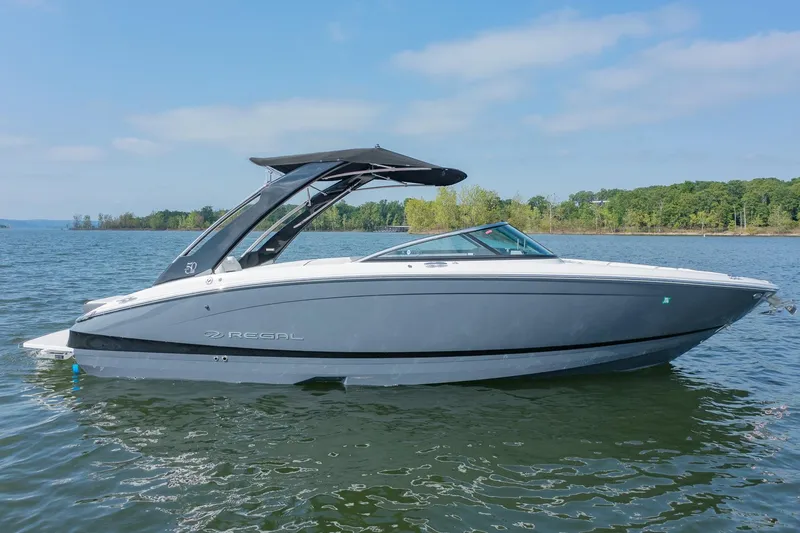Slide: The Image of 2021 Regal LS6 boat on a lake, sleek design, calm water, clear sky. - 1