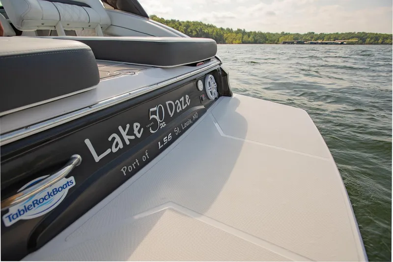 Slide: The Image of 2021 Regal LS6 boat named "Lake Daze" on a calm lake. - 10
