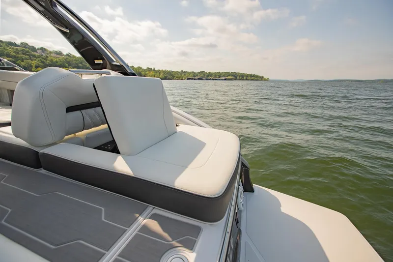 Slide: The Image of 2021 Regal LS6 boat with luxurious seating on a serene lake. - 13