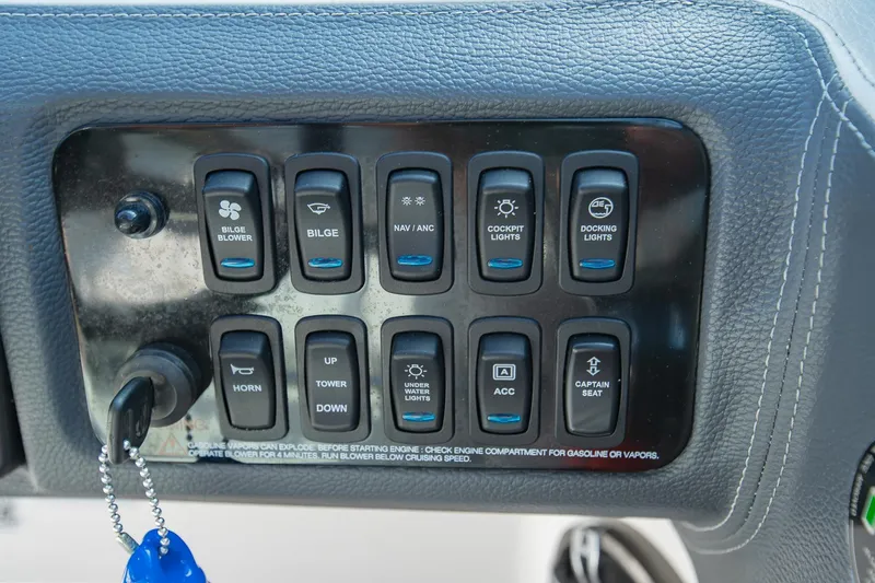 Slide: The Image of Control panel of a 2021 Regal LS6 boat with various switches and key. - 23