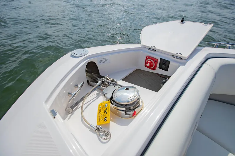 Slide: The Image of 2021 Regal LS6 boat anchor compartment with winch and safety equipment on open water. - 29