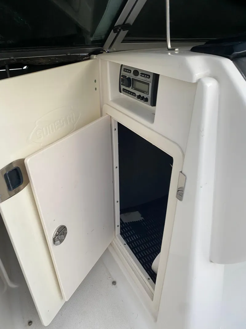 Slide: The Image of 2008 Chaparral Sunesta 244 boat interior with open storage compartment and control panel. - 11