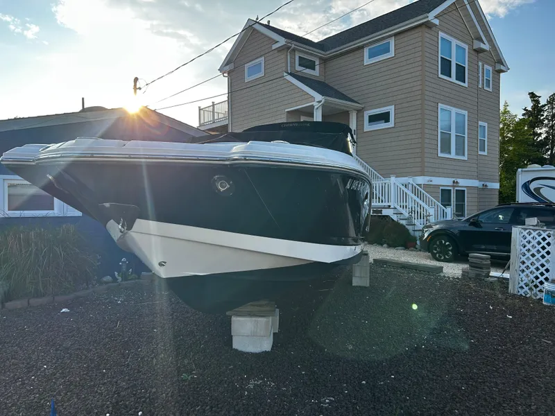 Slide: The Image of 2008 Chaparral Sunesta 244 boat on blocks, near a house, under a bright sky. - 4