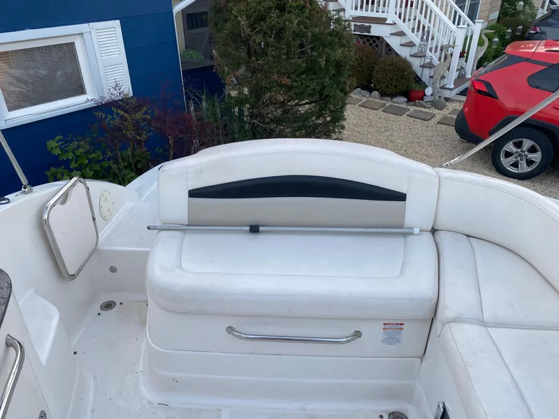 Slide: The Image of 2008 Chaparral Sunesta 244 boat interior with white seating and outdoor background. - 8