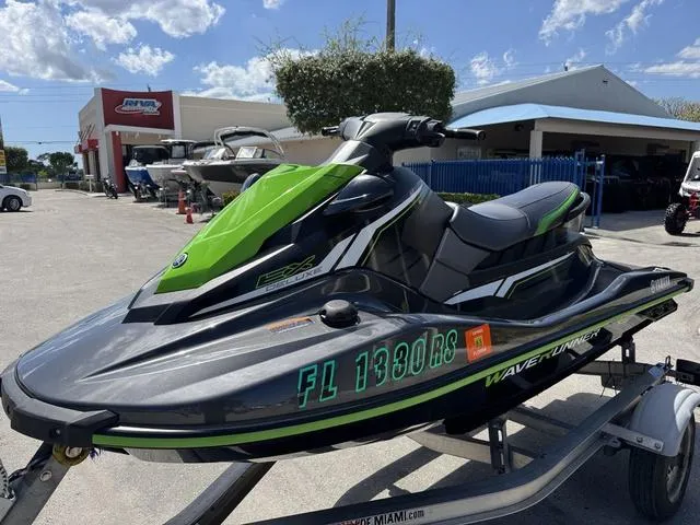 Slide: The Image of 2018 Yamaha WaveRunner EX jet ski in green and black on a trailer, outdoor dealership setting. - 2