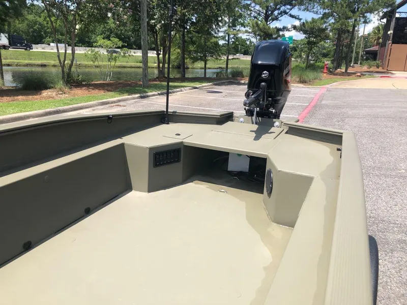 Slide: The Image of 2025 Tracker Grizzly 1650 T Prairie Wings Edition boat, rear view, parked outdoors. - 11