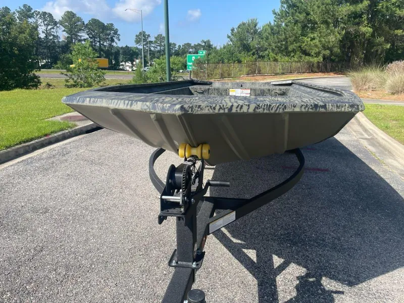 Slide: The Image of 2025 Tracker GRIZZLY 1860 Utility boat on trailer, parked outdoors. - 2