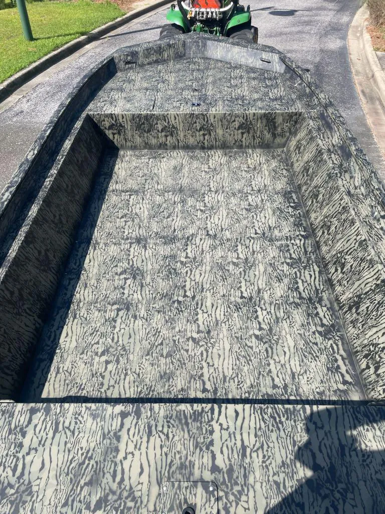 Slide: The Image of 2025 Tracker GRIZZLY 1860 Utility boat with camouflage interior on a road. - 3