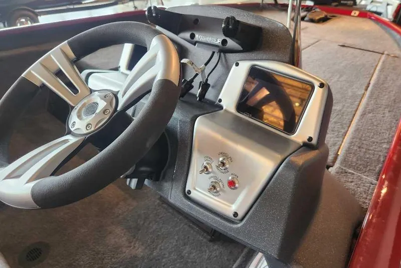 Slide: The Image of 2025 Tracker Savage 215 boat dashboard with steering wheel and control panel. - 89