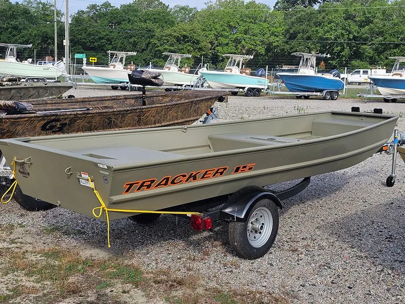 Slide: The Image of 2025 Tracker Grizzly 15 Jon boat on trailer, parked in a boatyard. - 3