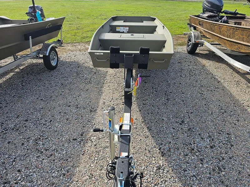 Slide: The Image of 2025 Tracker Grizzly 15 Jon boat on trailer, parked on gravel, with grassy background. - 4