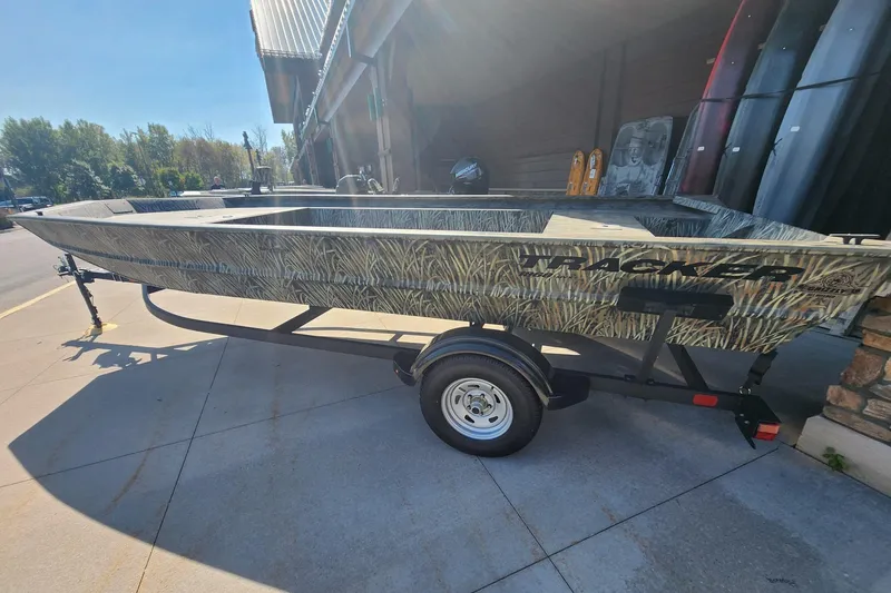 The Image of 2025 Tracker Grizzly 1860 Utility boat on trailer, parked outdoors. - 0