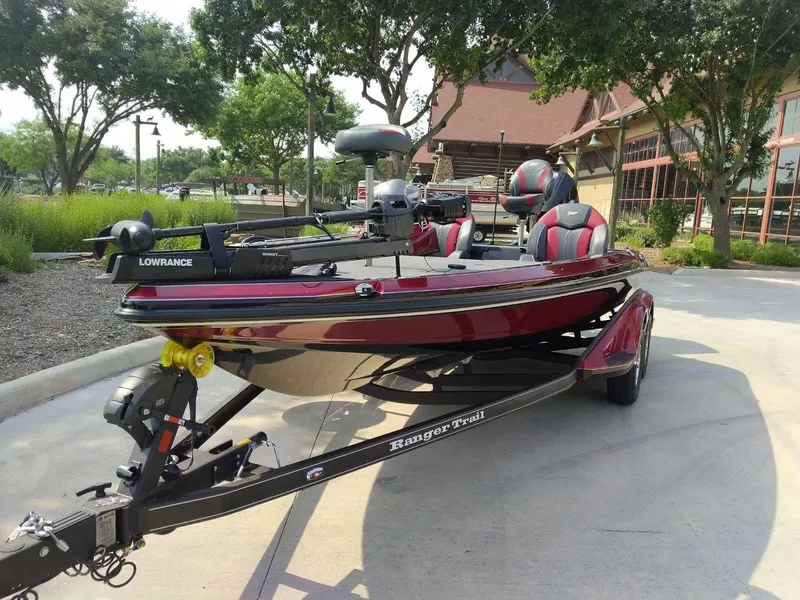 Slide: The Image of 2025 Ranger Z519R Cup-Equipped boat on trailer, parked outdoors near trees and building. - 2