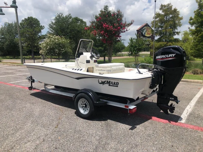 Slide: The Image of 2025 Mako Pro Skiff 15 CC boat on trailer with Mercury outboard motor. - 2
