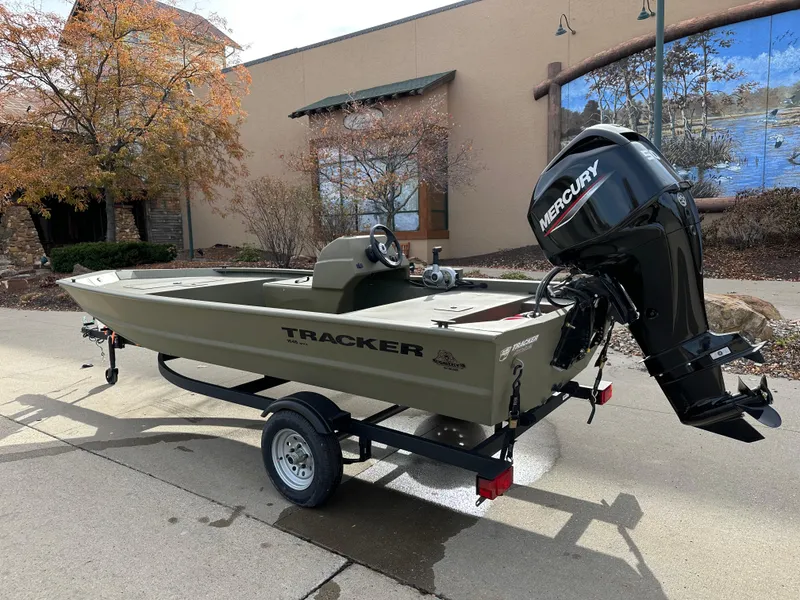 Slide: The Image of 2025 Tracker Grizzly 1648 SC boat with Mercury engine on trailer, outdoors. - 2