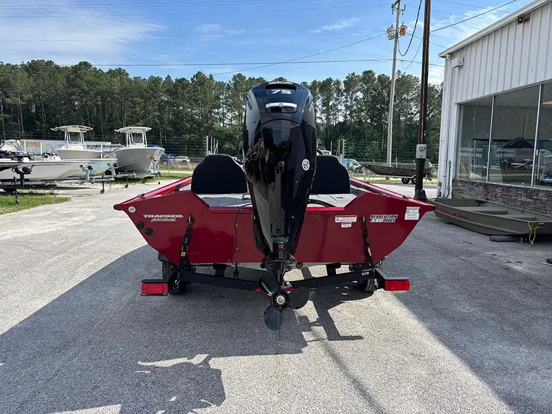 Slide: The Image of 2025 Tracker Pro Team 175 boat, red exterior, parked outdoors near a showroom. - 6