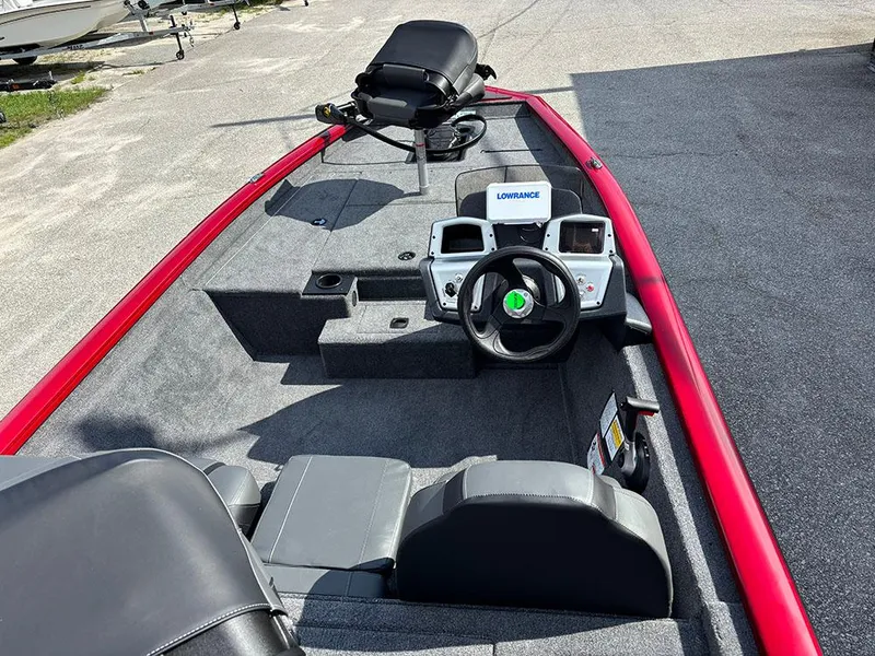Slide: The Image of 2025 Tracker Pro Team 175 boat interior with steering wheel and seating, featuring a red trim. - 9