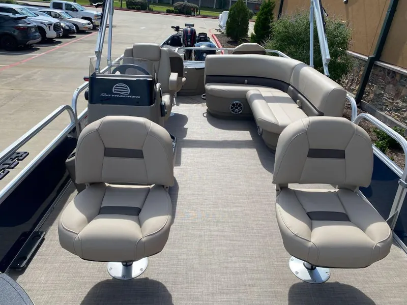 Slide: The Image of 2025 Sun Tracker Bass Buggy 18 DLX pontoon boat with beige seating and spacious deck. - 4