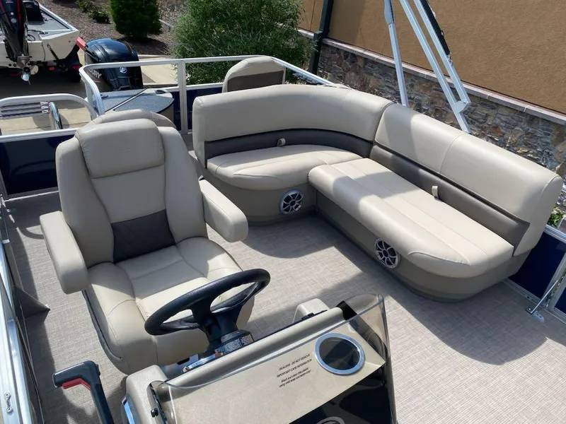 Slide: The Image of 2025 Sun Tracker Bass Buggy 18 DLX pontoon boat with beige seating and steering console. - 5