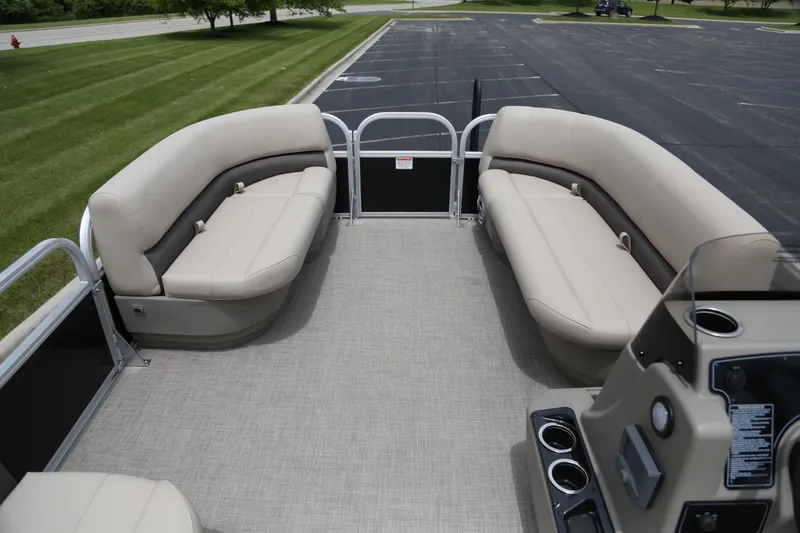 Slide: The Image of 2025 Sun Tracker Party Barge 16 DLX interior with beige seating and spacious deck. - 2