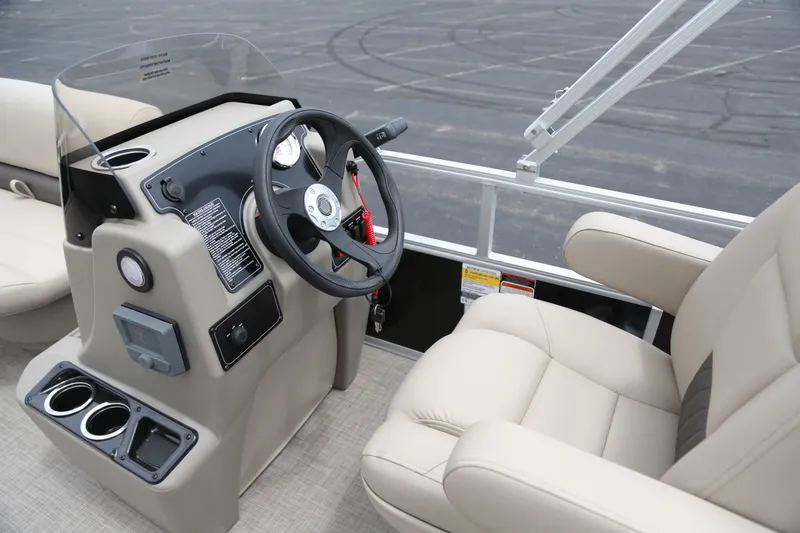 Slide: The Image of 2025 Sun Tracker Party Barge 16 DLX helm with beige seating and steering wheel. - 3